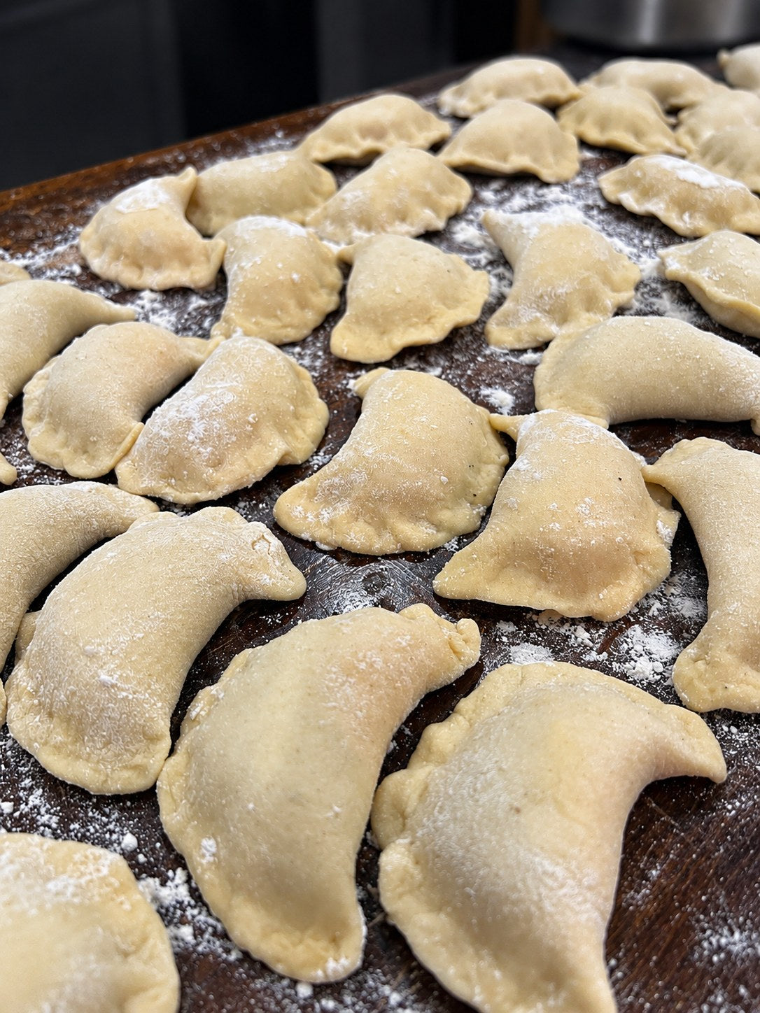 Fresh pierogies on a floured wooden board